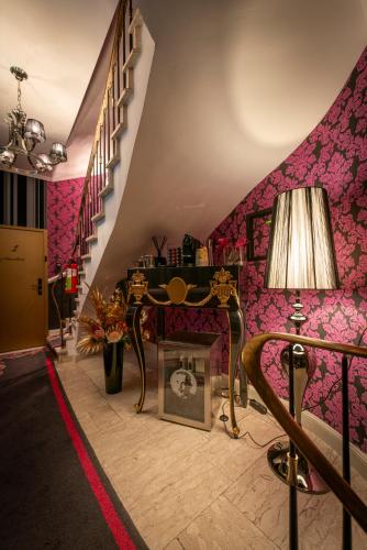 a living room with pink walls and a staircase at La Belle 10 in Cologne