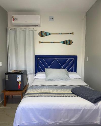 a bed with a blue headboard in a room at Pousada da Onça - Itapiranga, AM in Itapiranga