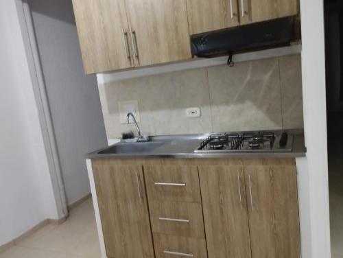 a kitchen with a sink and a stove at Apto de 3 habitaciones con ventiladores y parqueadero comunal in Valledupar