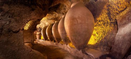 a row of vases lined up in a cave at Apartamentos Bobal Requena in Requena