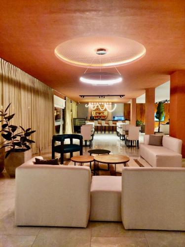 a living room with a couch and tables and chairs at Hotel Termal Los Cardones & Spa in Termas de Río Hondo