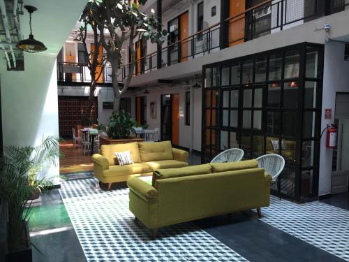 a living room with two yellow couches and chairs at Mini loft Buenavista 208 in Mexico City