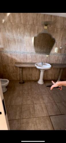 ein Bad mit einem Waschbecken und einem Spiegel in der Unterkunft Guest House Iguaçu in Foz do Iguaçu