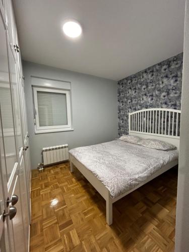 a small bedroom with a bed and a window at Apartman Obala in Bosanska Gradiška