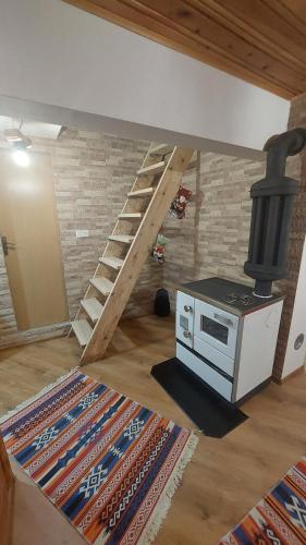 a room with a stove and a staircase in a house at Vikendica Rajvosa Vlašić in Šišava