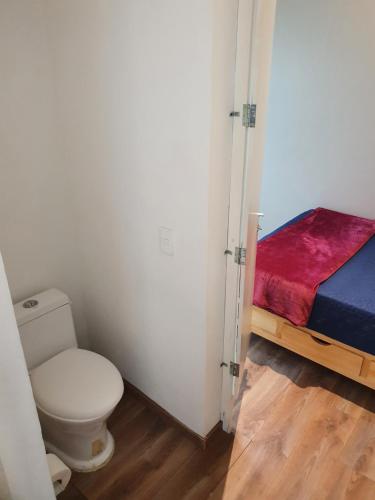 a small bathroom with a toilet and a bed at Mini loft Buenavista 208 in Mexico City