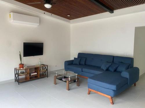 een woonkamer met een blauwe bank en een tv bij Casa Pacifico 46 Tamarindo in Santa Cruz