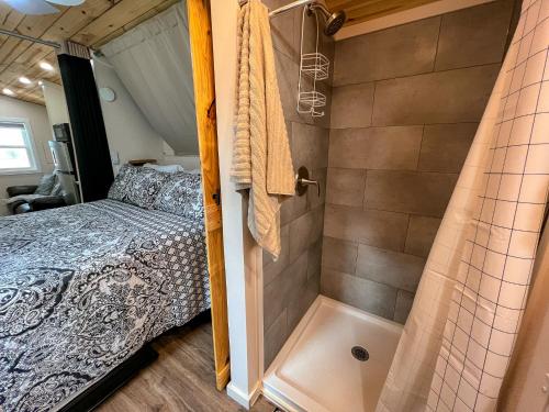a bedroom with a bed and a shower at Petite Retreat in West Jefferson