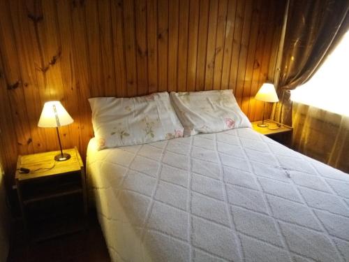 ポサーダスにあるLavalle hostelのベッドルーム1室(白いベッド1台、ランプ2つ付)