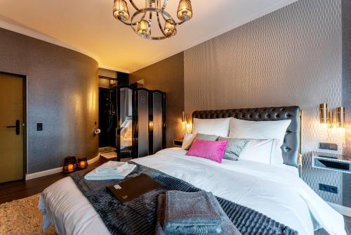 a bedroom with a large white bed with a pink pillow at La Belle 10 in Cologne