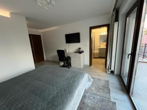a bedroom with a bed and a desk and a television at TREND in Arad