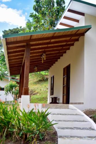 a house with a wooden roof at Tarcoles Birding Lodge in Tarcoles
