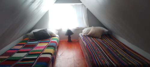 a attic bedroom with two beds and a window at Cabaña Ermelinda in San Carlos de Bariloche