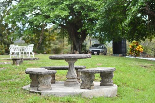 a stone table and benches in a park at Tarcoles Birding Lodge in Tarcoles