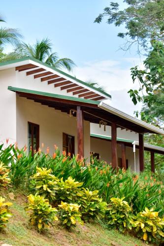 a house with flowers in front of it at Tarcoles Birding Lodge in Tarcoles