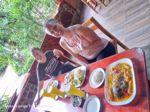 een man en een jongen aan een tafel met eten bij Amazon Jungle Tour Expedition in Tena