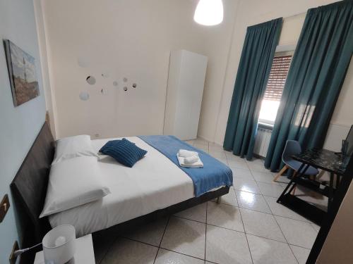 una camera da letto con un letto con tende blu e un tavolo di Nalusa Home a Sarno