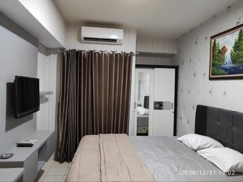 A bed or beds in a room at Apartemen Serpong Green View by Heaven Rooms