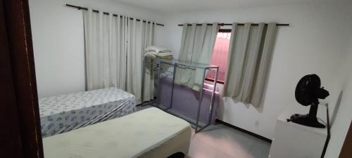 um quarto com duas camas e um telefone em Casa Barra do Jucu 50m da praia em Vila Velha