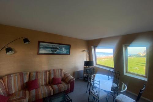 un salon avec un canapé et une table en verre dans l'établissement Cozy love cocoon of 34 m direct access to the sea, à Bernières-sur-Mer
