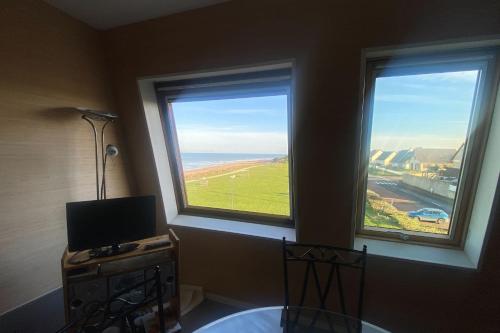 Cette chambre dispose de deux fenêtres offrant une vue sur l'océan. dans l'établissement Cozy love cocoon of 34 m direct access to the sea, à Bernières-sur-Mer