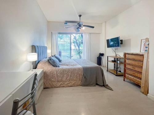 a bedroom with a bed and a window and a television at Estudio en Caballito: Comodidad y Estilo- Lamas in Buenos Aires