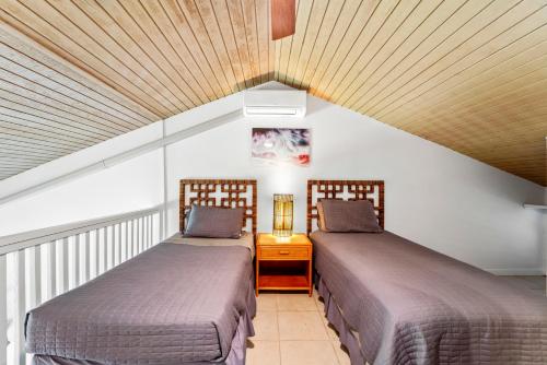 twee bedden naast elkaar in een kamer bij Turtle Bay Townhouse Steps to Our Beautiful Beach! in Kahuku