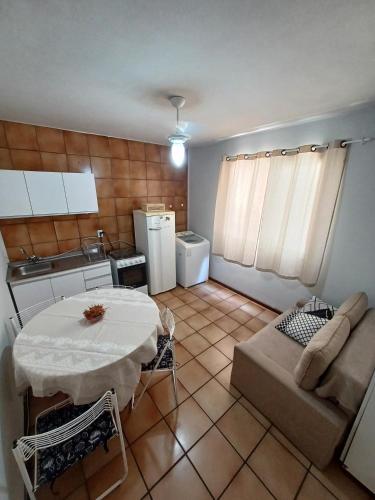 a kitchen with a table and a couch in a room at Apto Centro Floripa 01 in Florianópolis