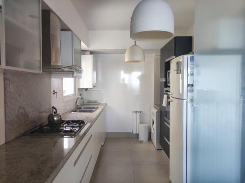 a kitchen with a white refrigerator and a stove at Excelente Vista al Golf y al Mar in Mar del Plata