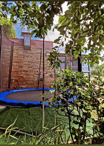 a swing in a yard next to a brick wall at Lilie location sud in Petite Île