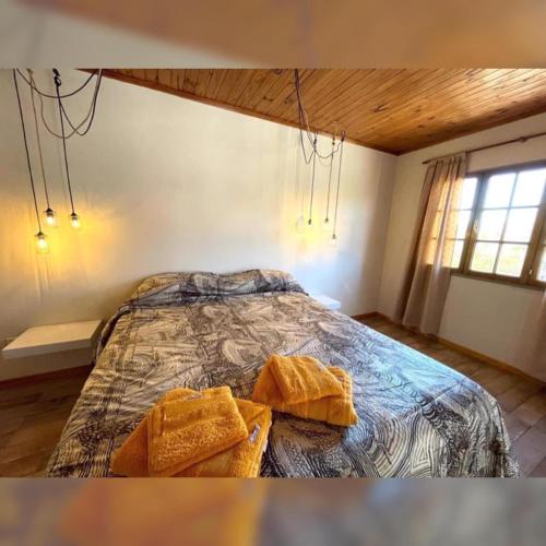 Un dormitorio con una cama con dos toallas encima. en Sauce Tempo, en Esquel