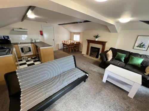 a large living room with a couch and a kitchen at The Hideaway Holywell in Holywell