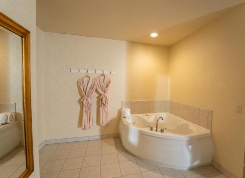 a white bathroom with a tub and a sink at Silverland Inn in Virginia City