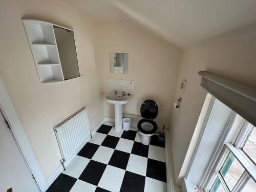 a bathroom with a black and white checkered floor at The Hideaway Holywell in Holywell