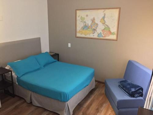 a bedroom with a bed and a blue chair at Mini Loft 107 in Mexico City