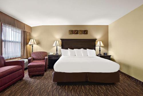Best Western Center Pointe Inn في برانسون: غرفه فندقيه بسرير وكرسي