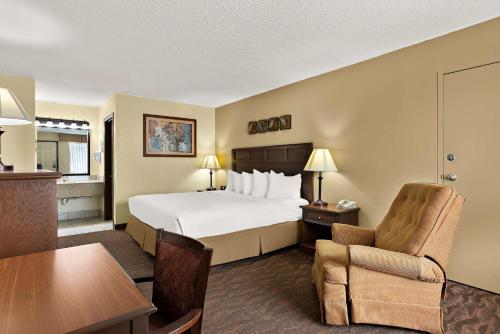 a hotel room with a bed and a desk and chair at Best Western Center Pointe Inn in Branson