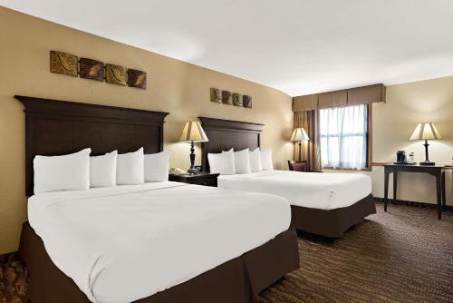 a hotel room with two beds and a desk at Best Western Center Pointe Inn in Branson