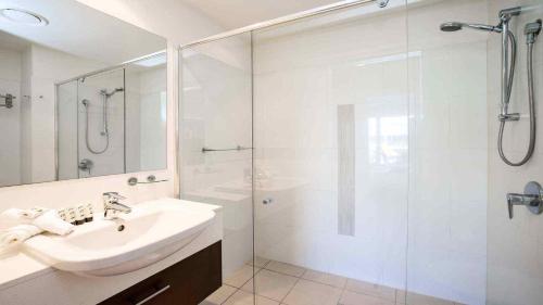 a white bathroom with a sink and a shower at 2BR Resort Living: 2-Bed Haven in Gold Coast