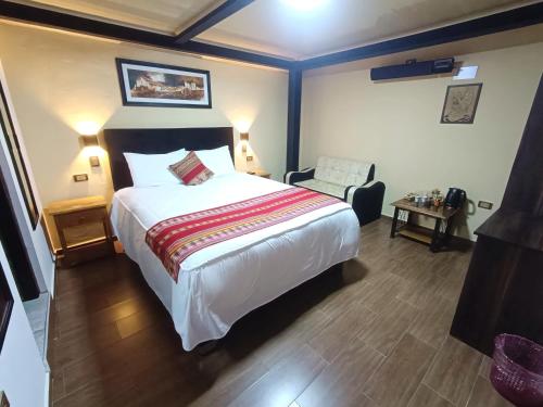 1 dormitorio con 1 cama grande y 1 silla en La Posada del Viajero en Cusco