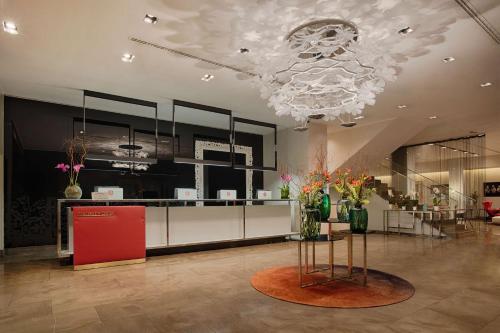 a lobby with a red refrigerator and a chandelier at NH Collection Milano President in Milan