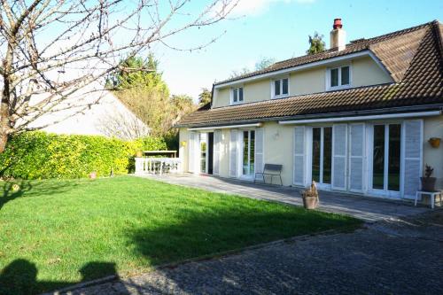 uma casa branca com um quintal com um relvado sidx sidx em M&A maison de campagne/ Disney/Paris/Wifi/Jeux em Croissy-Beaubourg