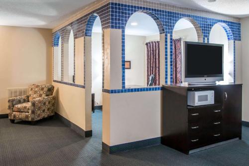 a waiting room with a tv and a chair at Country Inn & Suites by Radisson, Battle Creek, MI in Battle Creek