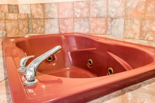 a red sink with a faucet in a bathroom at Country Inn & Suites by Radisson, Battle Creek, MI in Battle Creek