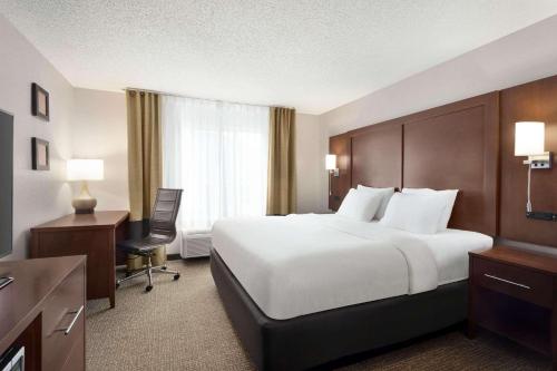 Cette chambre comprend un grand lit et un bureau. dans l'établissement Country Inn & Suites by Radisson, Stillwater, MN, à Stillwater