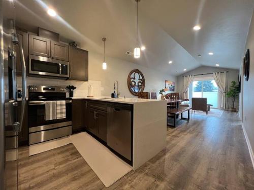 cocina con electrodomésticos de acero inoxidable y comedor en Modern Style KING bed Free Wi-Fi with Garage, en Spokane Valley