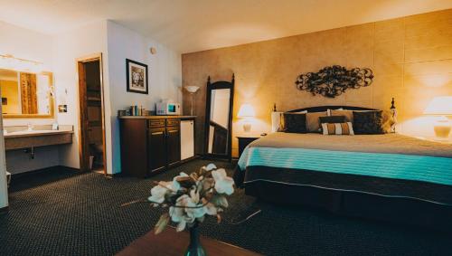 una camera d'albergo con un letto e un lavandino di Wrangler Inn Mobridge a Mobridge