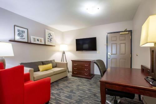una sala de estar con sofá y mesa en una habitación de hotel en Country Inn & Suites by Radisson, Tucson City Center AZ, en Tucson