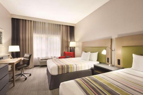ein Hotelzimmer mit 2 Betten und einem Schreibtisch in der Unterkunft Country Inn & Suites by Radisson, Fresno North, CA in Fresno