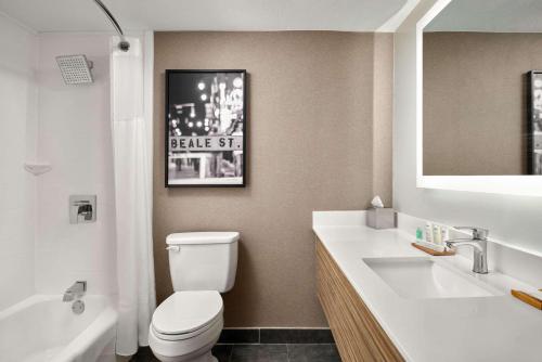 bagno con servizi igienici, lavandino e specchio di Radisson Hotel West Memphis a West Memphis